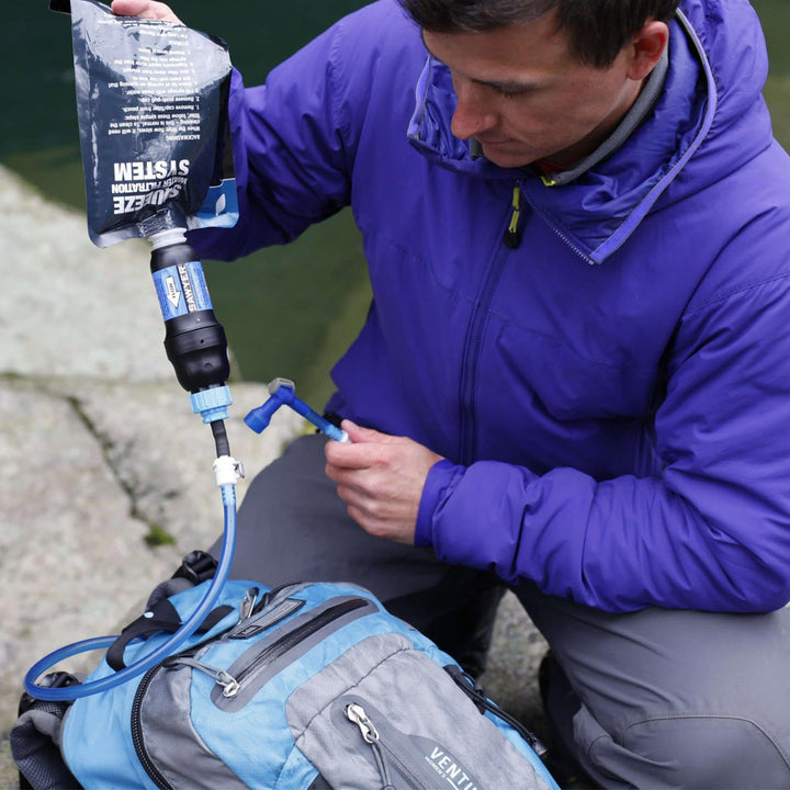 man using Sawyer SP115 to fill camel pack